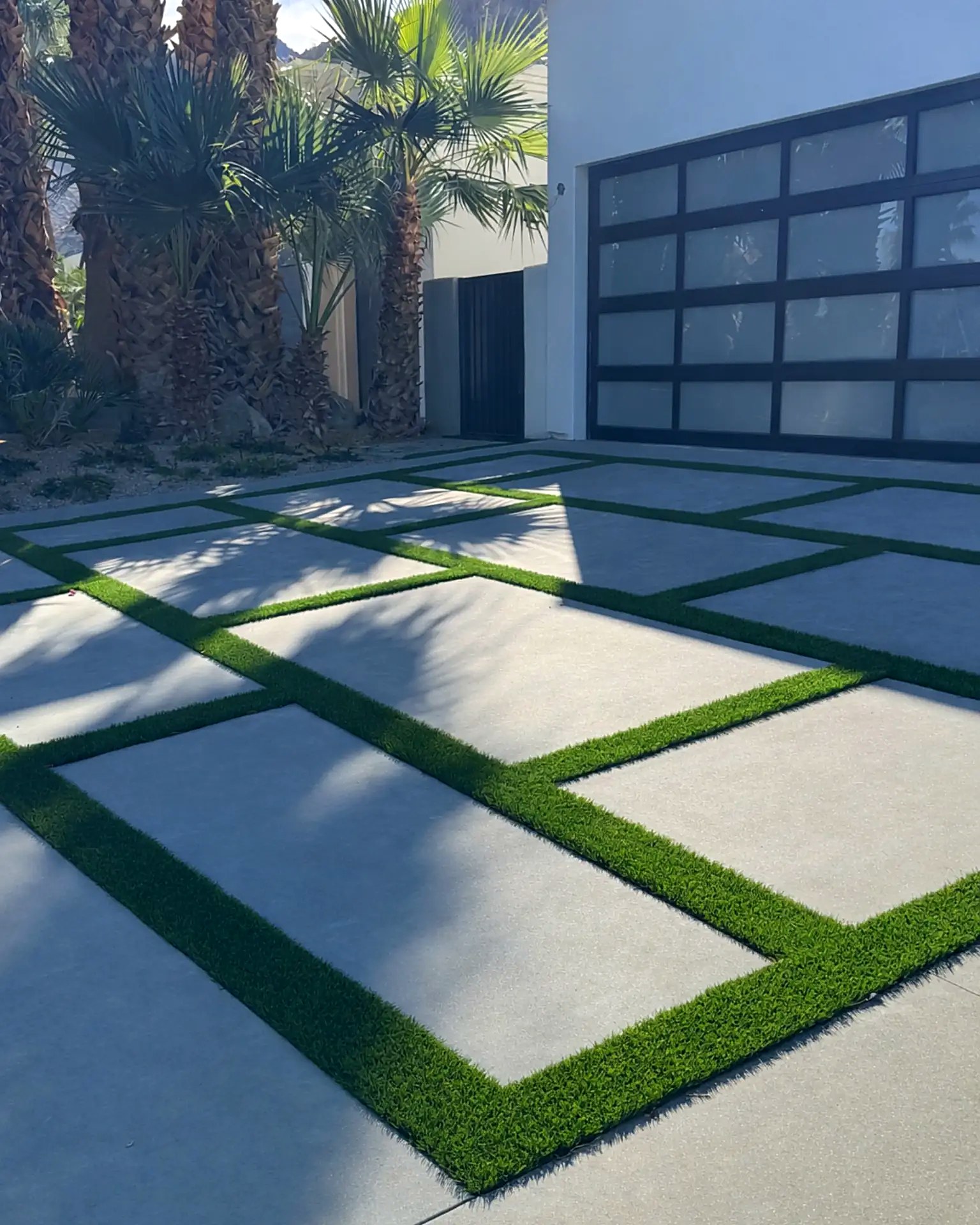 Close view of oversized concrete pads floated in artificial turf ribbons