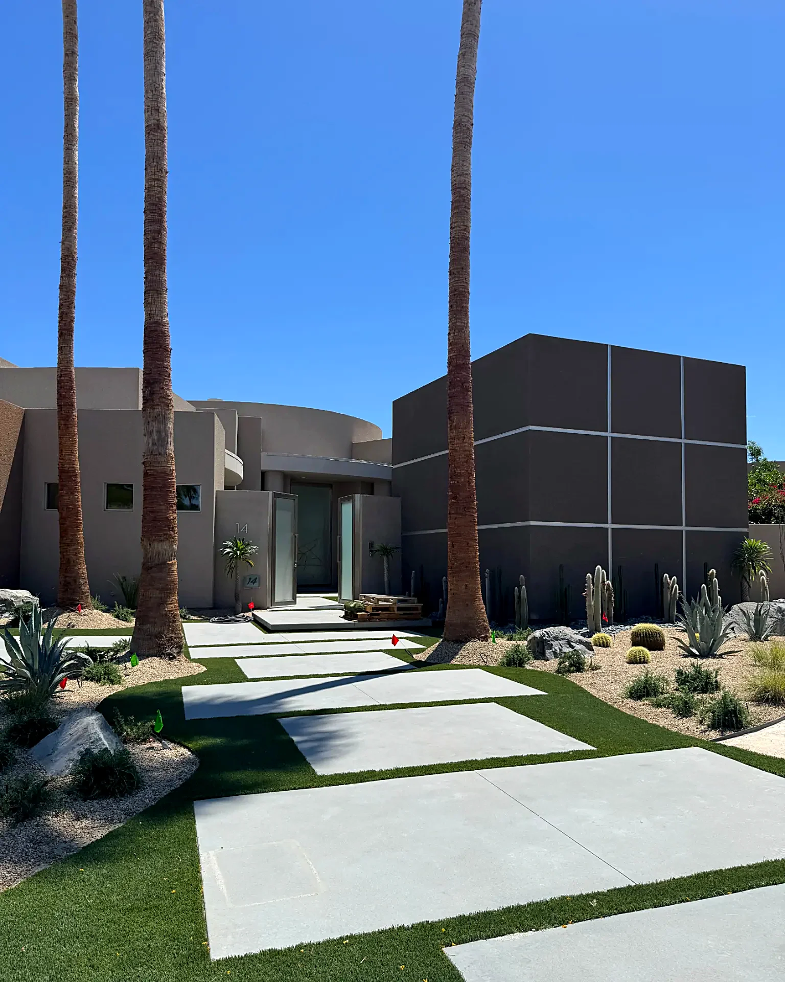 Modern desert front yard with large concrete stepping stones set in turf