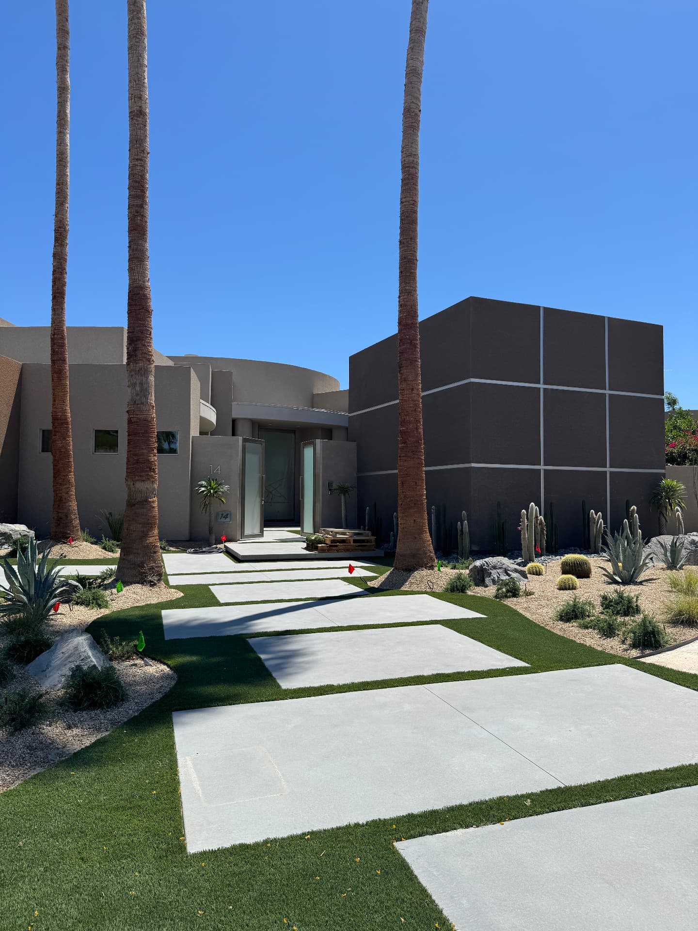 Large concrete stepping pads floated through turf at a modern entry