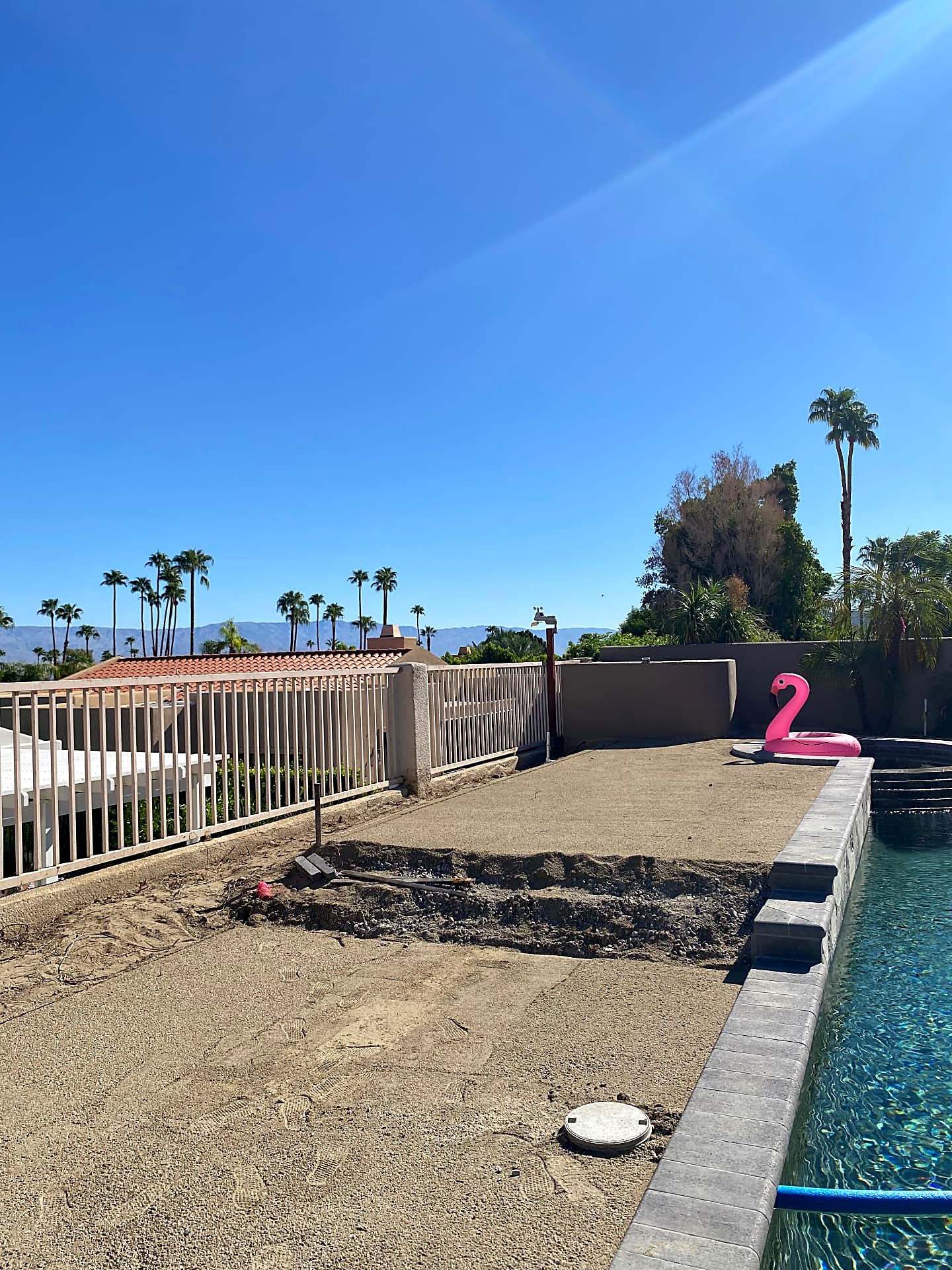 Pool deck and backyard before renovation — old concrete removed and graded for new landscape