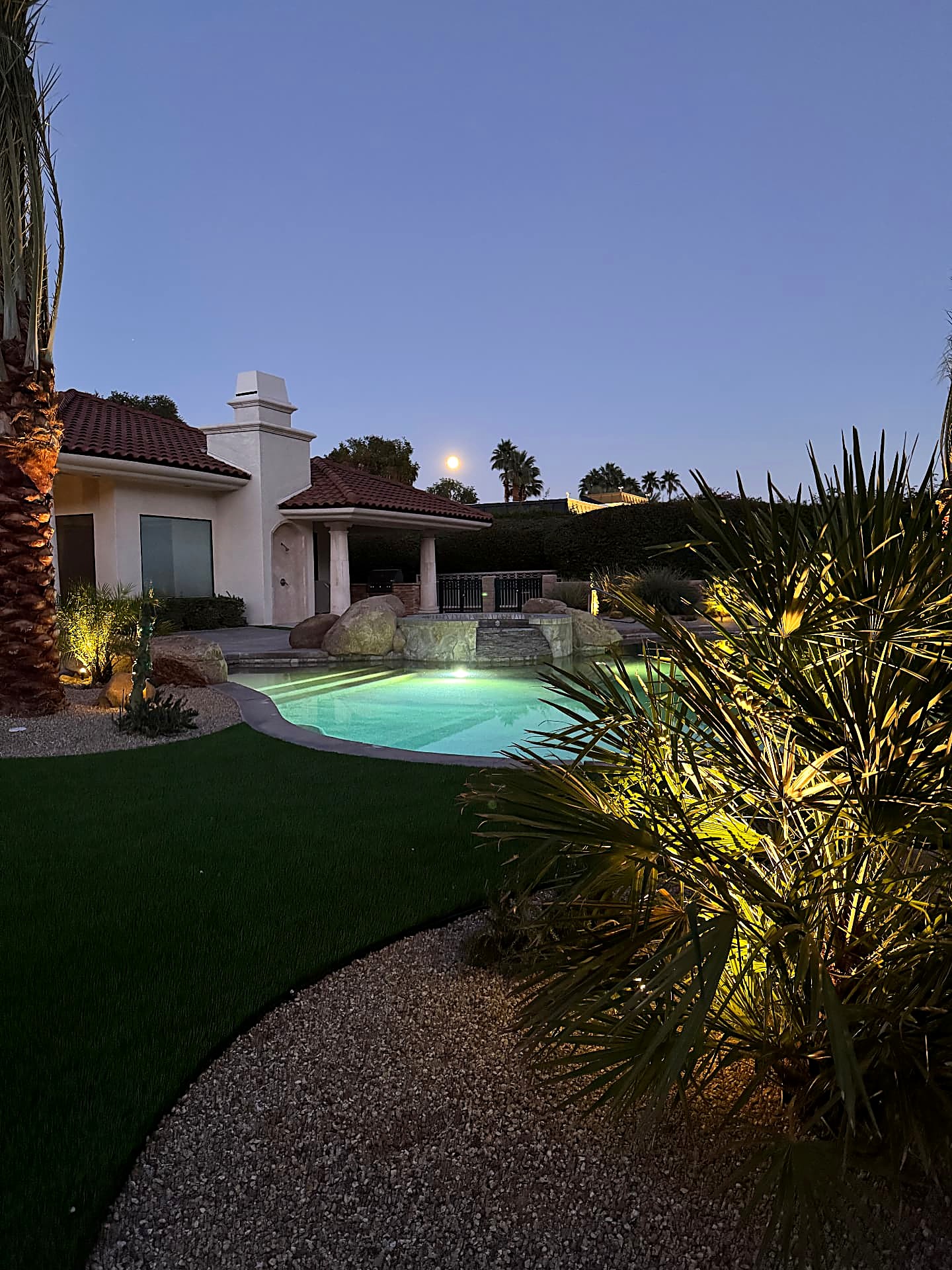 Illuminated pool and landscape lighting washing over the garden at dusk